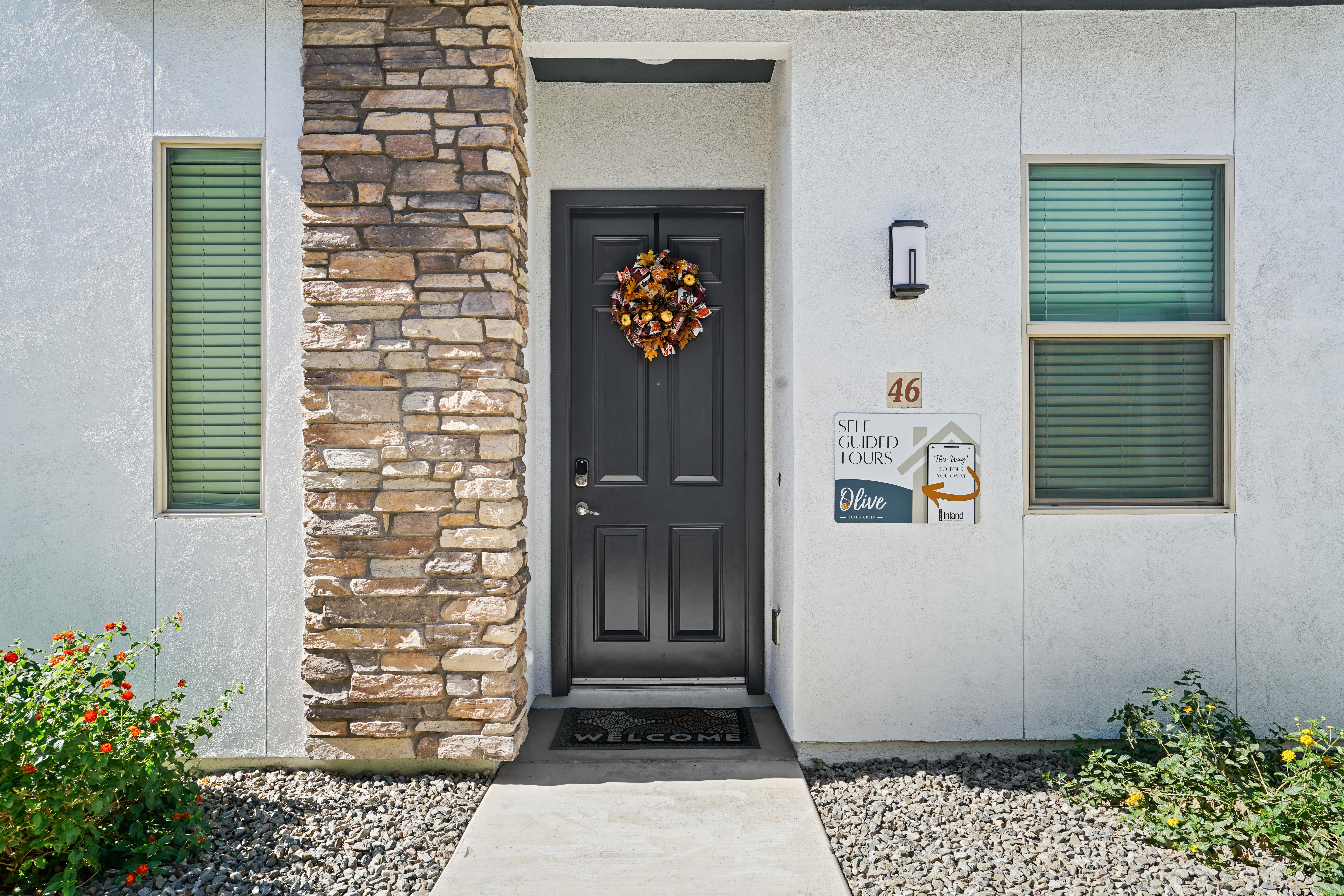 a front door of a house with a wreath on it at Olive Queen Creek Apartments, Queen Creek, AZ